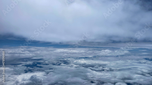 View from airplane above clouds and city