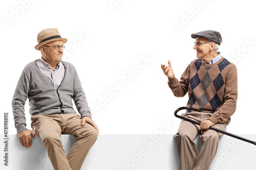 Elderly men sitting on a panel and talking