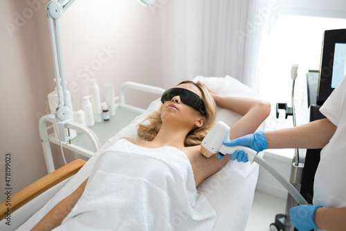 Fotografía Beautiful blonde lying down on a couch during armpit laser hair removal