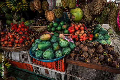 Fototapeta Naklejka Na Ścianę i Meble -  Fruit shop in Thailand. Fruit market in Indonesia Bali island. Street bazaar in Asia. Sale of fresh fruits and vegetables at the market in Thailand. A small grocery store on the street of Bali island