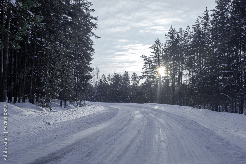 Winter landscape with a snow-covered road in the forest Winter landscape with a snow-covered road in the forest