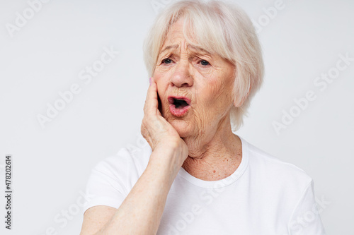 Portrait of an old friendly woman health lifestyle migraine light background