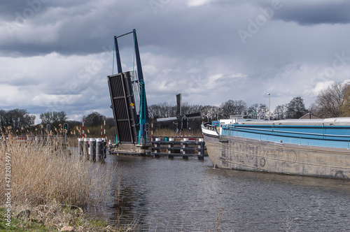 cargo boat approaches a lift bridge in river Oude IJssel near the village of Laag Keppel © henkbouwers