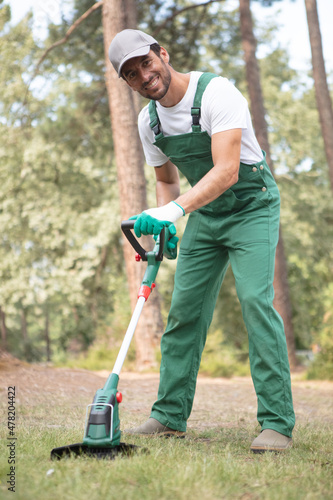 male gardener is using a trimmer