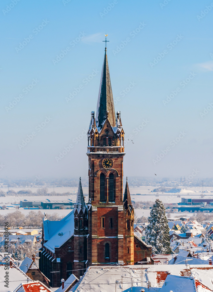 An old Alsatian town under the snow. The bell tower of the cathedral and the roofs of medieval houses. An old Alsatian town under the snow. The bell tower of the cathedral and the roofs of medieval houses.