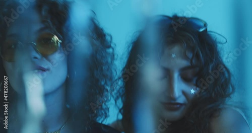 Curly girls dancing through a glitter curtain. photo