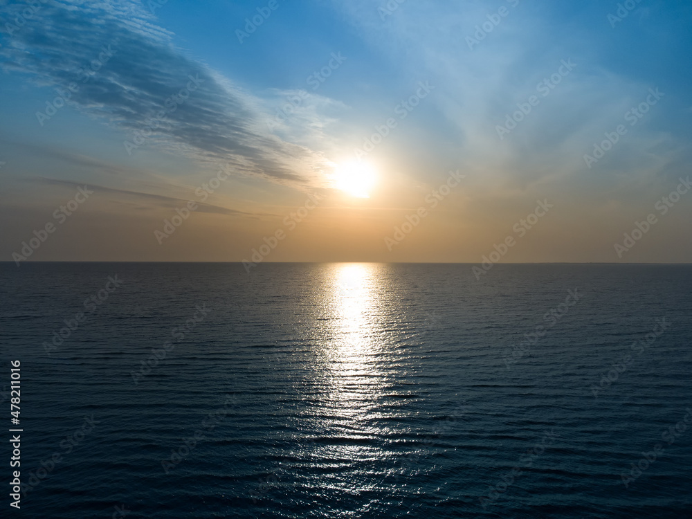 Beautiful sunset over the sea horizon and cloudy sky.