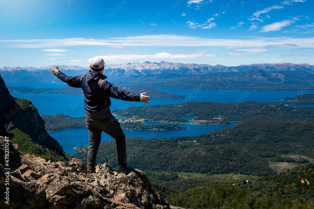 Hombre admirando las vistas de los lagos de Bariloche desde cerro de gran altura Hombre admirando las vistas de los lagos de Bariloche desde cerro de gran altura