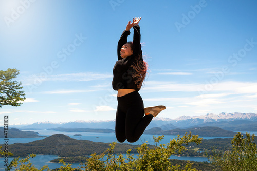 Mujer saltando en el cerro Lopez, en el circuito chico de la ciudad de Bariloche. Patagonia Argentina