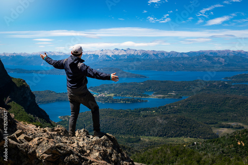 Hombre admirando las vistas de los lagos de Bariloche desde cerro de gran altura