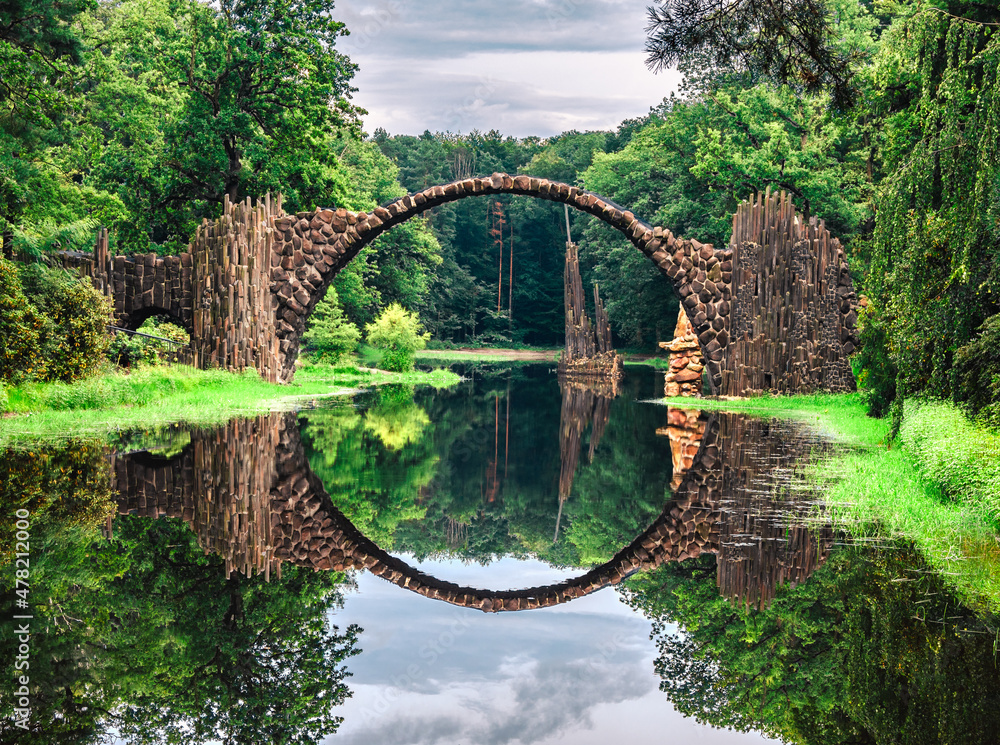 Rakotz Bridge, Rakotzbrucke in Kromlau, Saxony, Germany. Fantastic landscape in Azalea and Rhododendron Park Kromlau. Reflection of bridge in water of Rakotzsee. traveling and travel goals for tourism