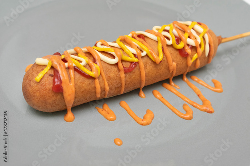 Salchichas empanizadas con mayonesa y ketchup, servidas con aderezo picante