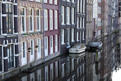 Amsterdam Damrak Canal Building Facades and Boats with their Reflection in the Water, Netherlands © Monica
