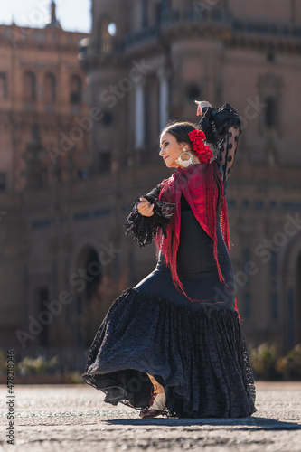 Woman in black and red flamenco costume dancing outdoors