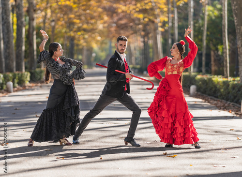 Man with two female flamenco dancers dancing on a park