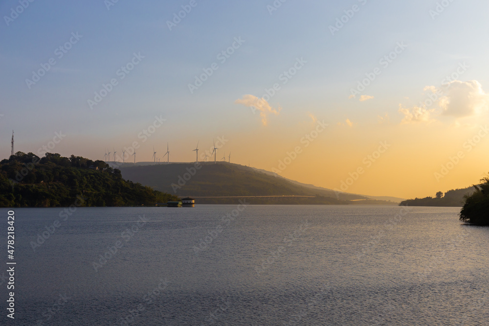 Landscape mountain view and reservoir with wind turbine and motor way at Lam Ta Khong, Sikhio, Nakhon Ratchasima, Thailand at sunset