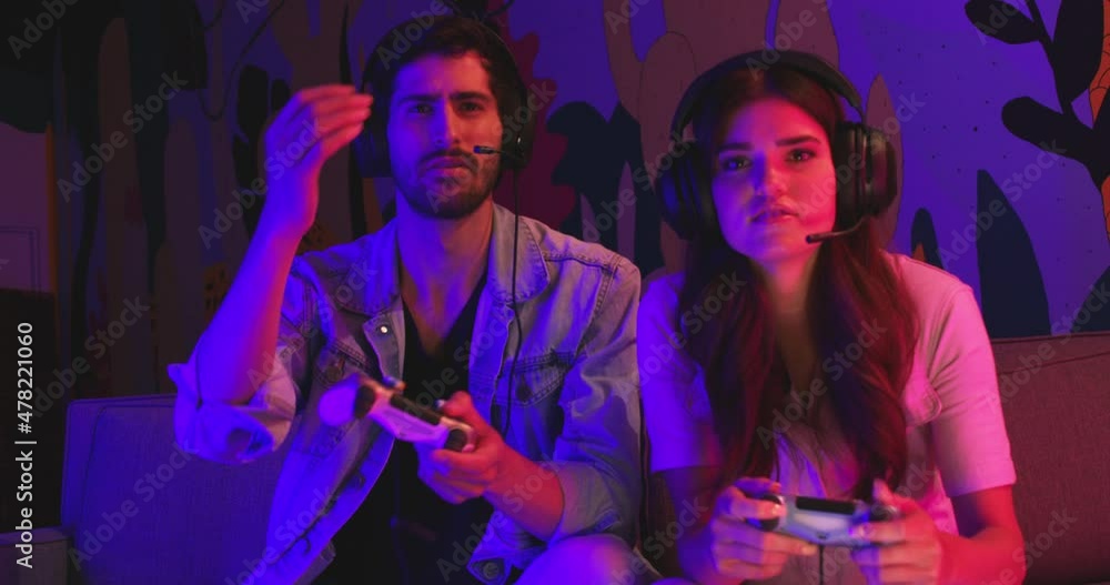 Couple plays game while sitting in front of mural