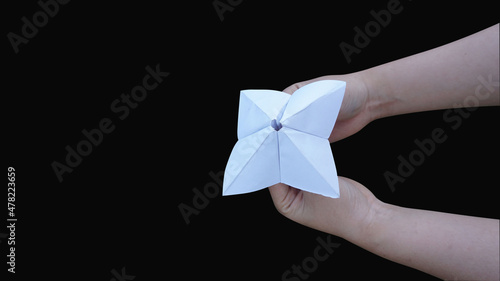 Hand holding fortune telling paper isolated on a black background with clipping path photo