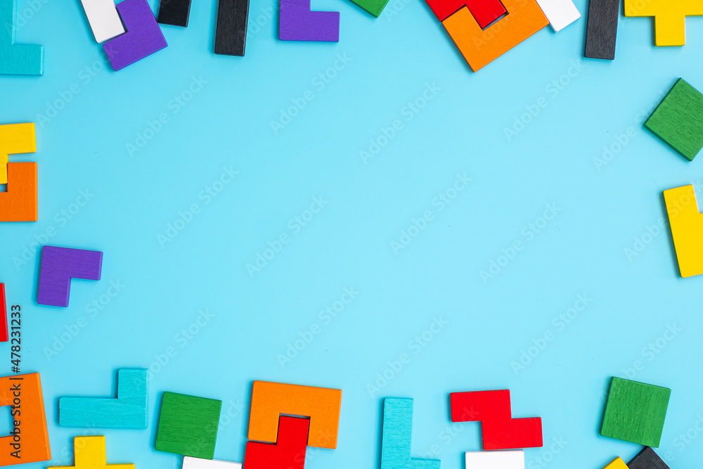 colorful wood puzzle pieces on blue background, geometric shape block with copy space. Concepts of logical thinking, Conundrum, solutions, rational, strategy, world logic day and Education