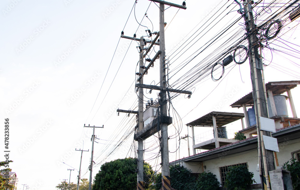 Transformers and electric wire. Transformers and phone lines against and bright sunlight blue cloud sky copy space. Energy and technology. Electrical post by the road with power line cables lamp.. Transformers and electric wire. Transformers and phone lines against and bright sunlight blue cloud sky copy space. Energy and technology. Electrical post by the road with power line cables lamp..