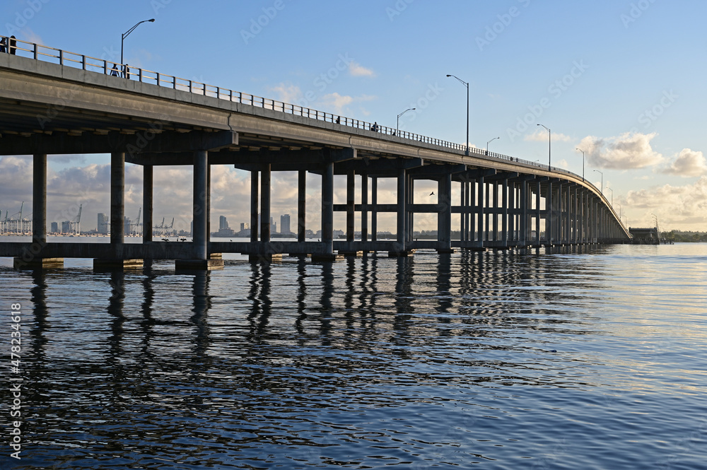 Rickenbacker Causeway bridge in Miami, Florida reflected in calm water of Biscayne Bay on clear sunny morning..