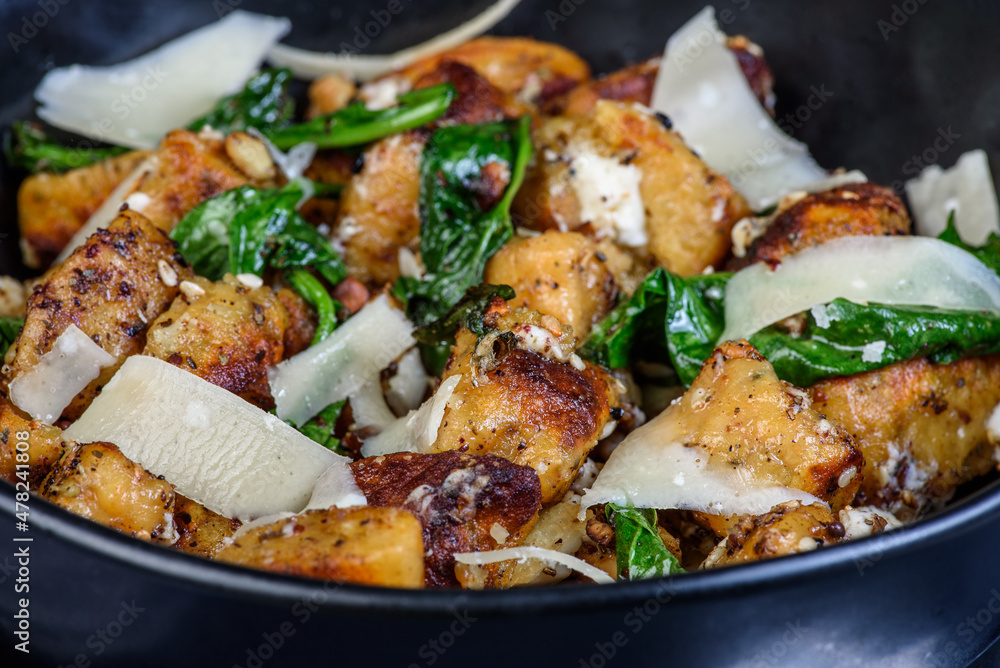 A close up view of a serving of pumpkin gnocchi in a round bowl.