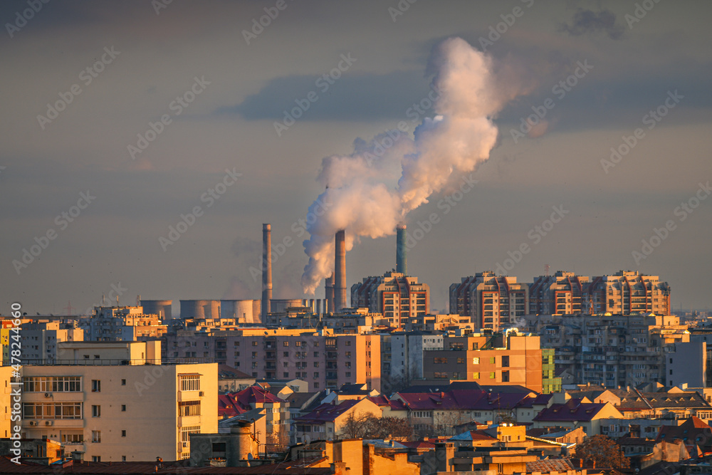 Bucharest from above. Aerial view of its central heating system over the city. The smoke is creating clouds in the sky during this freezing morning.