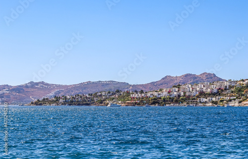 Blue sea sparkling in the sun. Beautiful coast with islands, mountains and yachts