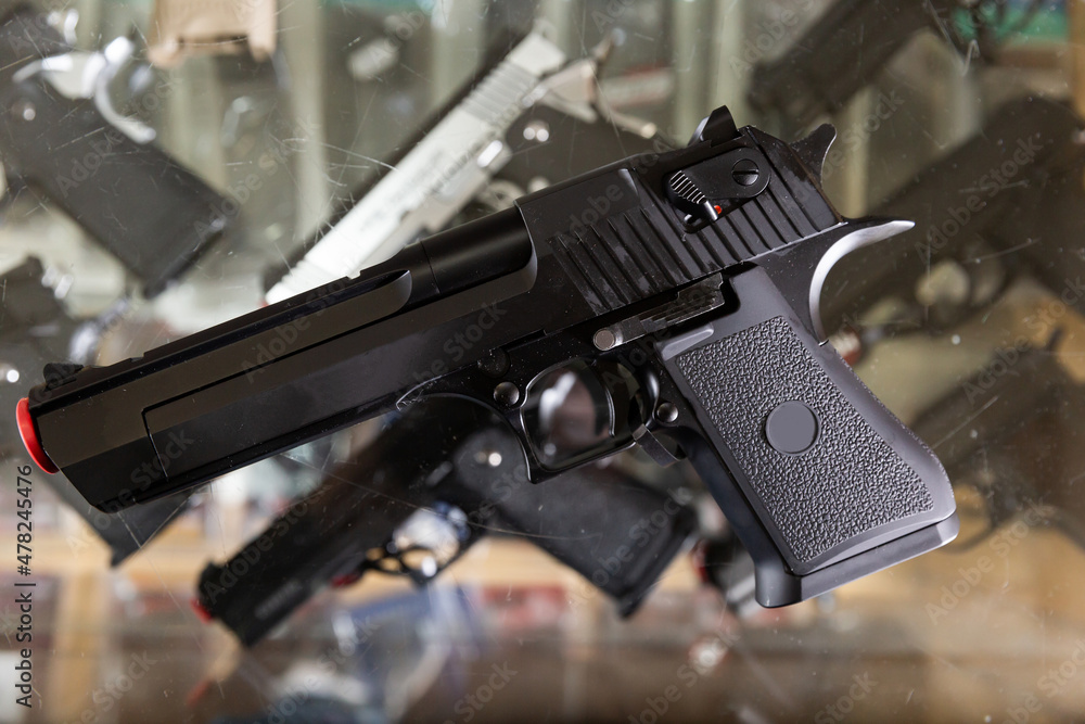 Obraz premium Pistol on showcase in weapon shop. Exemplar of firearm weapon.
