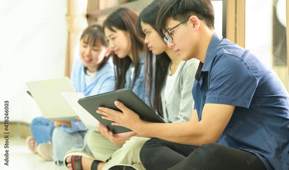 A team of young people sitting on the floor using laptops and tablets. A team of young people sitting on the floor using laptops and tablets.