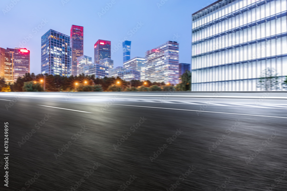 Fototapeta premium Motion blurred asphalt road and modern commercial building landscape in Beijing, China.