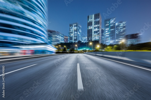 Motion blurred asphalt road and modern commercial building landscape in Beijing, China.