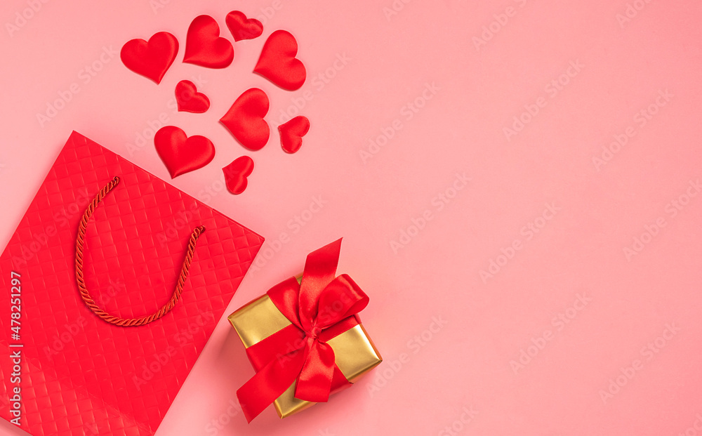 Red paper bag, red hearts and gift satin ribbon bow pink background. Festive background valentines day Red paper bag, red hearts and gift satin ribbon bow pink background. Festive background valentines day
