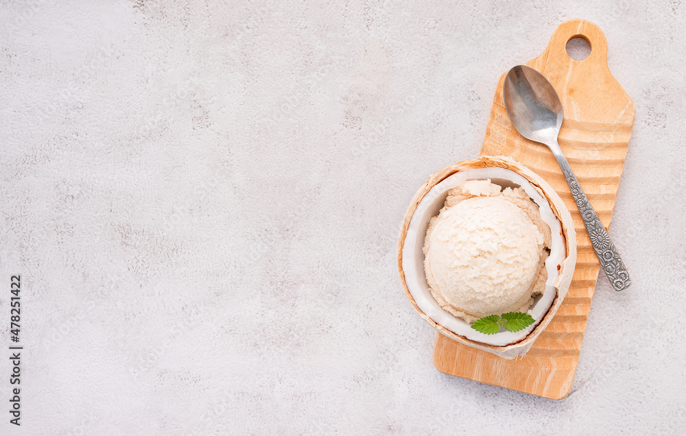 Coconut ice cream flavours in half of coconut setup on white stone background. Summer and Sweet menu concept. Coconut ice cream flavours in half of coconut setup on white stone background. Summer and Sweet menu concept.