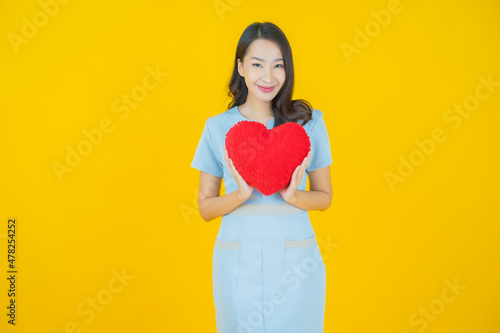 Portrait beautiful young asian woman smile with heart pillow shape