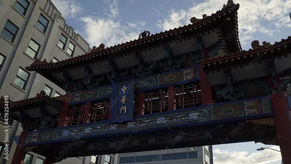 Beautiful tilting up shot of the famous Seattle Chinatown International District entrance gate near the subway and restaurants on a sunny summer day in Washington, USA. Beautiful tilting up shot of the famous Seattle Chinatown International District entrance gate near the subway and restaurants on a sunny summer day in Washington, USA.