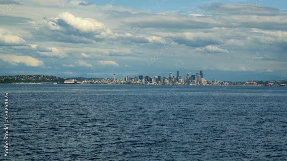 Super wide trucking right shot of the beautiful cityscape of Seattle with the Space Needle, Skyscrapers, and the coastline on a warm cloudy summer day in Washington State, USA. Super wide trucking right shot of the beautiful cityscape of Seattle with the Space Needle, Skyscrapers, and the coastline on a warm cloudy summer day in Washington State, USA.