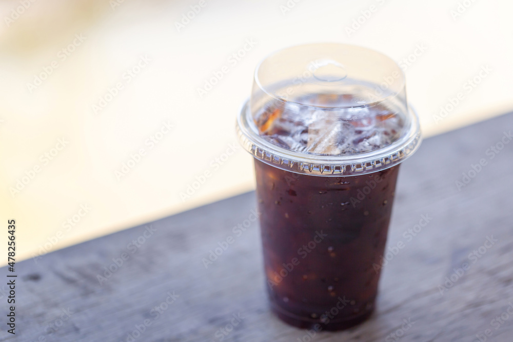Glass of iced americano coffee on wooden table Glass of iced americano coffee on wooden table