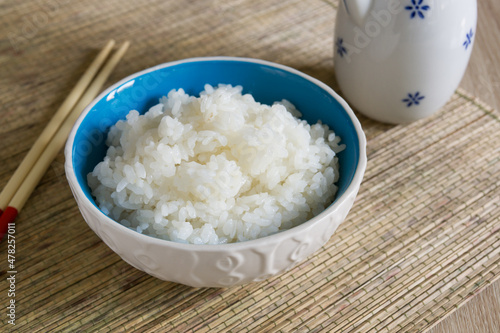 Obraz na plátně Japanese steamed Uruchimai rice in a pretty ceramic bowl with chopsticks