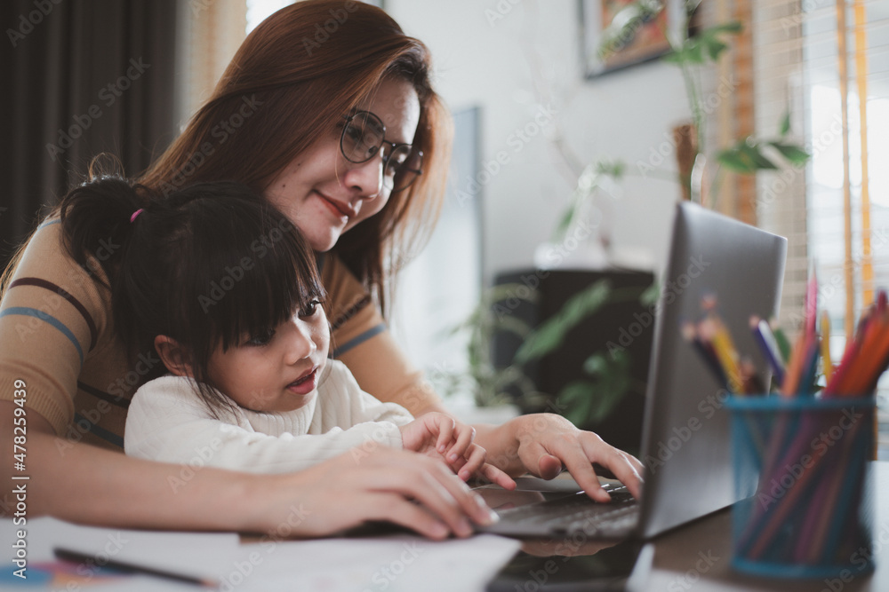 Mother working at home-office with daughter on her lap Mother working at home-office with daughter on her lap