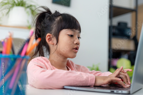 Asian girl using Laptop computer for online study homeschooling during home quarantine. homeschooling, online study, home quarantine, online learning, corona virus or education technology concept