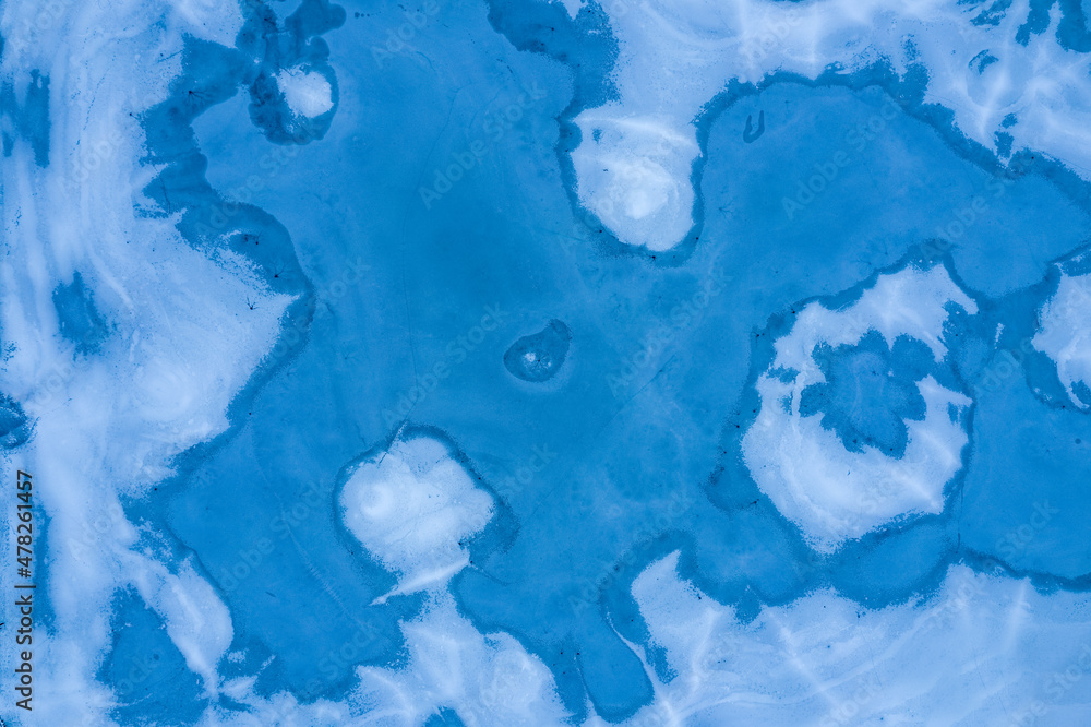 Aerial view of a frozen lake. Abstract blue background. Melting ice, climate change and environmental conservation.