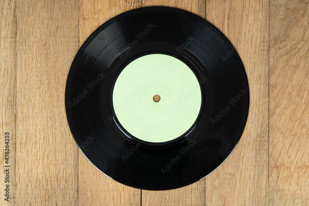 Obraz premium Old vinyl disc on wooden background. Old vintage vinyl record.