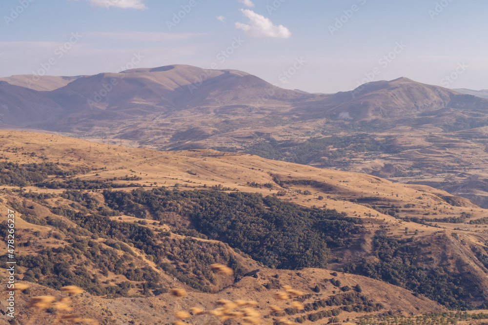 Armenia mountain autumn view. Dry land mountain range and steppe picturesque landscape view with blue sky. Stock photography.