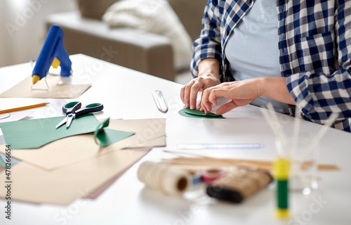 diy, art and hobby concept - close up of woman making paper craft at home