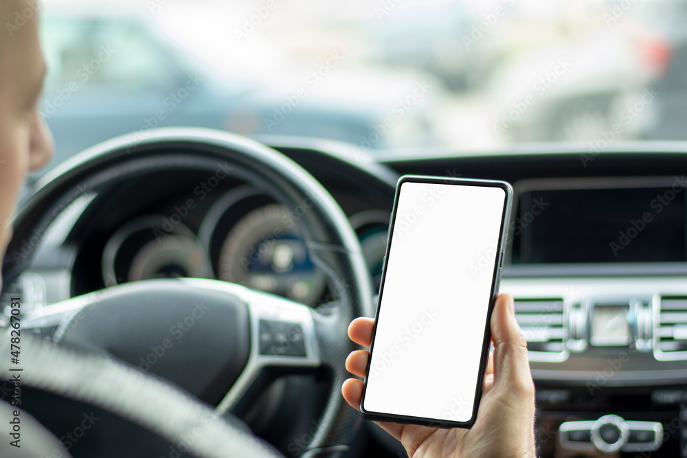 Man driver using smart phone in car during traffic jam, blank white screen for design purpose 