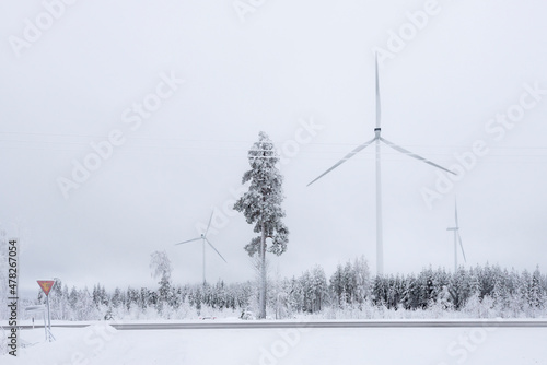 Windmills in Finland. White winter landscape with snow producing green and sustainable energy