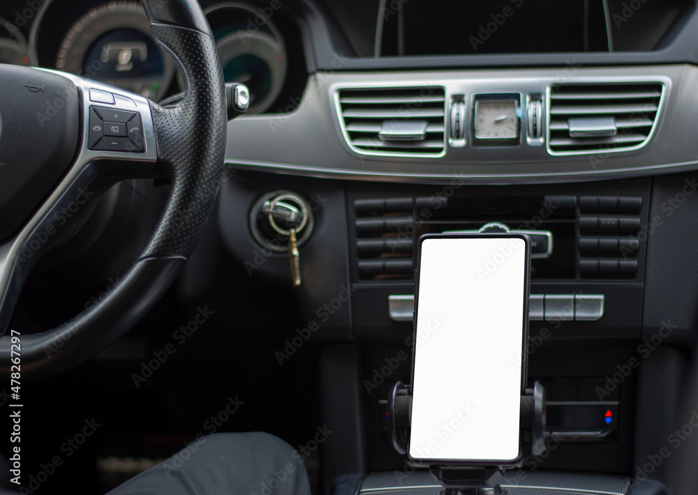 Smartphone in a car use for Navigate or GPS. Driving a car with Smartphone in holder. Mobile phone with isolated white screen. Blank empty screen. Empty space for text. Copy space