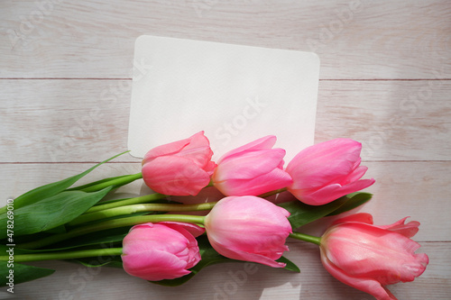 Fototapeta Naklejka Na Ścianę i Meble -  Beautiful color tulip flowers composition with blank card on white wooden table. floral background for Mother's day, Women's day, Easter and Spring time.