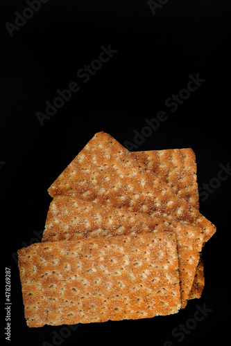 Four crispbreads on black surface. High angle shot with copy spacein the upper part of vertical photo. photo